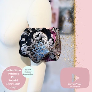 May include: A black bubble sleeve with floral embroidery in blue, silver, and pink hues, displayed on a mannequin arm. The sleeve is part of a PDF tutorial, with sizes ranging from small to large. The image also includes a YouTube video instruction link.