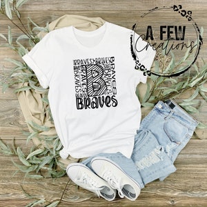 May include: White t-shirt with a black graphic design of the letter "B" made up of the word "Braves" repeated multiple times. The word "Braves" is also written below the letter "B".