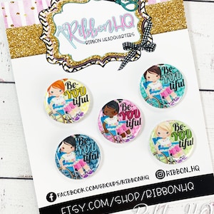 May include: Set of four 1.5 inch round buttons with a colorful design featuring a girl in a wheelchair and the text "Be You Tiful".