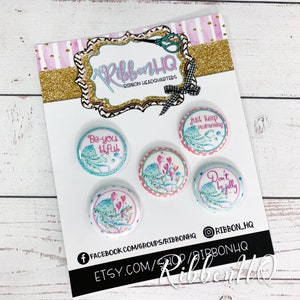 May include: Set of five 1.5 inch round buttons with a jellyfish theme. The buttons feature various sayings including "Be-you-tiful", "Just Keep Swimming", and "Don't Be Jelly".
