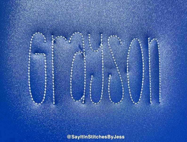 May include: The name "Grayson" is stitched in white thread on a blue background.
