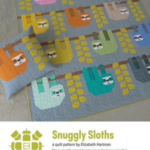 May include: A light blue quilt and pillow set featuring colorful sloth designs hanging from branches. The sloths are in various colors, including pink, orange, and green. The text "Snuggly Sloths" is visible.