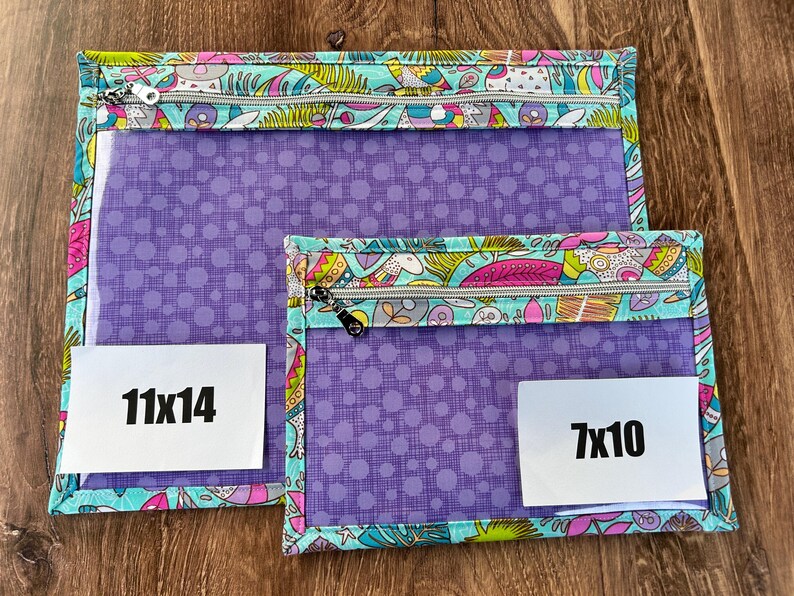 Puede incluir: Dos bolsas con cremallera. La bolsa m&aacute;s grande mide 28x36 cm, y la m&aacute;s peque&ntilde;a 18x25 cm. Ambas tienen un frente transparente, tela morada con lunares y un borde estampado colorido con cremalleras.
