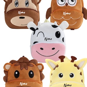 Może przedstawiać: Pięć pluszowych plecaków w kształcie zwierząt. Plecaki mają kształt małpy, sowy, krowy, lwa i żyrafy. Każdy plecak ma zapięcie na zamek błyskawiczny i nadruk z napisem "Name". Małpa jest brązowa, sowa pomarańczowa, krowa biało-różowa, lew brązowy, a żyrafa żółta.