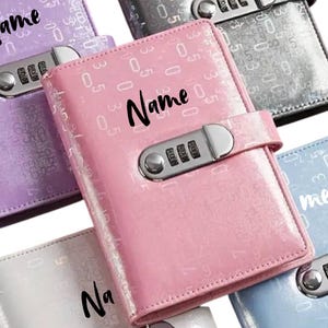 Könnte beinhalten: Eine Sammlung farbenfroher, glänzender Journale mit Zahlenschlössern. Die Journale sind in den Farbtönen Rosa, Lila, Silber und Blau gehalten. Auf jedem Journal steht das Wort "Name".