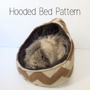 May include: A brown and white hooded bed for small pets, with a chevron pattern. A small furry animal is inside the bed.