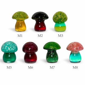 May include: A collection of eight colorful glass mushroom figurines. Each mushroom has a unique color combination, including green, yellow, red, and blue. The figurines are labeled M1 through M8.