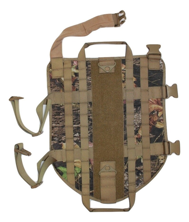 May include: A camouflage dog harness with adjustable straps and buckles. The harness has a handle on the top and a D-ring on the side.