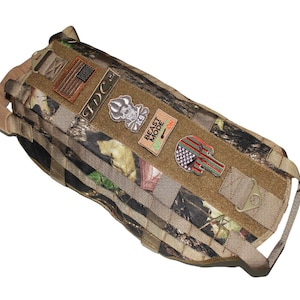 May include: A camouflage dog harness with multiple patches, including an American flag, a skull and crossbones, and a patch that says "Beast Mode".