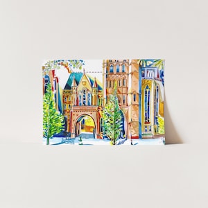 May include: A watercolor painting of a university building with a large archway and two trees in front. The building is painted in shades of red, orange, yellow, and blue. The trees are green and the sky is blue.