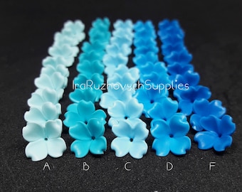 May include: A row of five blue and turquoise flower-shaped polymer clay embellishments, labelled A through F, with the colour gradient ranging from light blue to dark blue.