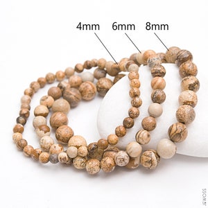 Puede incluir: Tres hebras de cuentas de piedras preciosas marrones y beige, con tamaños etiquetados de 4 mm, 6 mm y 8 mm.
