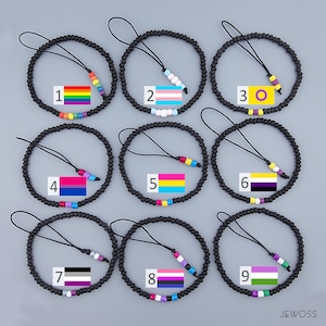 Könnte beinhalten: Neun schwarze Perlenarmbänder mit verschiedenen farbigen Perlen und Pride-Flaggen. Die Armbänder sind von 1 bis 9 nummeriert.