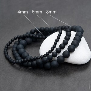 Könnte beinhalten: Drei schwarze Perlenarmbänder mit verschiedenen Perlengrößen. Die Armbänder sind mit 4 mm, 6 mm und 8 mm gekennzeichnet.
