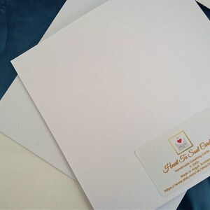 May include: A white card with a gold and red logo that says "Heart To Send Cards" and the website address "http://www.hearttosendcards.com". The card is on a blue surface.