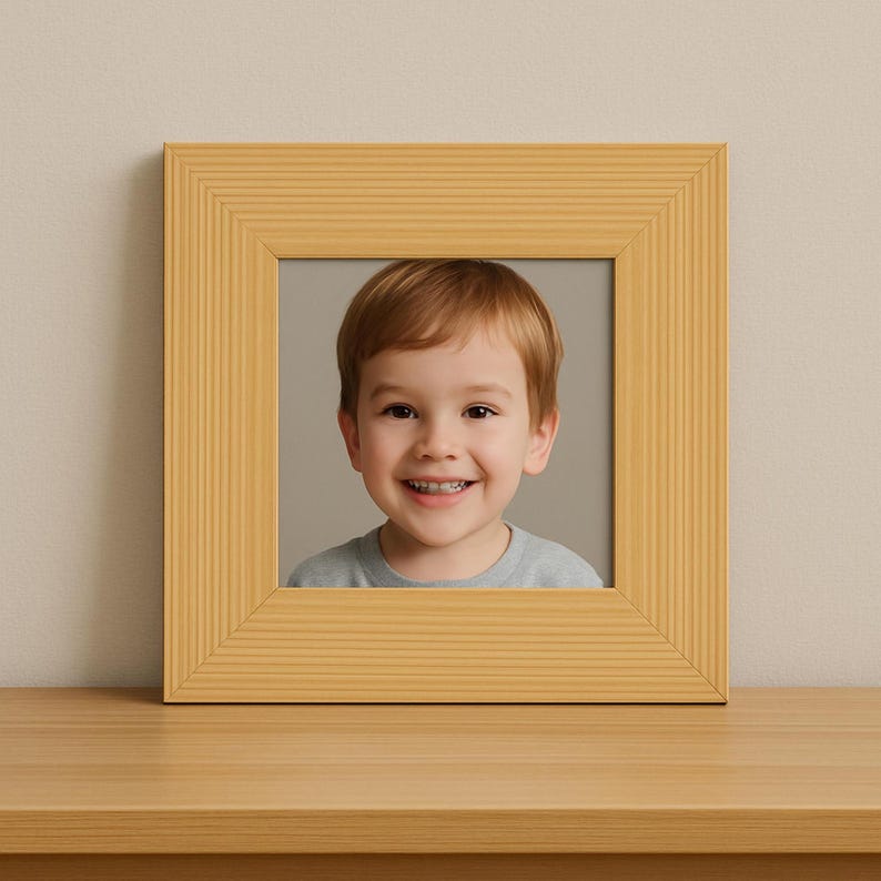 A high-quality, front-facing product photograph of a handmade 3x3 inch wood picture frame from New Jersey Frames, set on a wooden surface against a neutral, minimalist wall. The frame is crafted from solid pine with a clean, light natural wood finish. Inside the frame is a professional portrait of a smiling young boy with light brown hair, demonstrating how perfectly the frame displays cherished family photos, mini prints, or special keepsakes in a cozy, elegant, and timeless style.