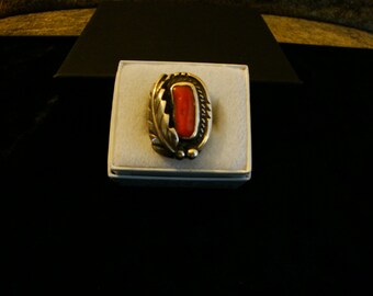 May include: A silver ring with a red coral stone set in a leaf design.