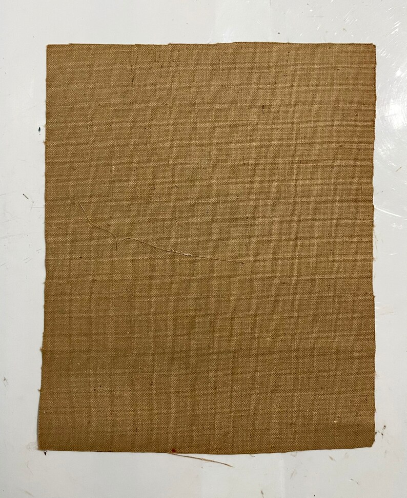 May include: A piece of brown burlap fabric with a woven texture.