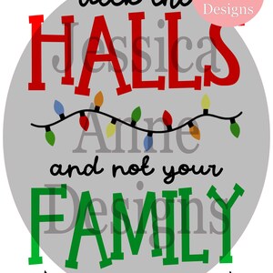 Może przedstawiać: Szare koło z tekstem "deck the halls and not your family" w czerwonych i zielonych literach. Tekst jest otoczony łańcuchem kolorowych światełek choinkowych. Tekst "Jessica Anne Designs" znajduje się w różowym polu w prawym górnym rogu. Tekst "FALALALALALALALALALA" znajduje się na dole koła.