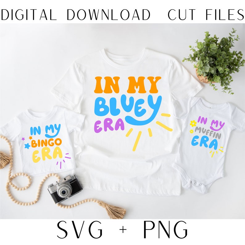 May include: Three white t-shirts with colorful text and graphics. The largest shirt says "In My Bluey Era" with a blue and yellow sun graphic. The medium shirt says "In My Bingo Era" with a yellow star and a yellow sun graphic. The smallest shirt says "In My Muffin Era" with a pink star and a yellow sun graphic.