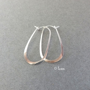 May include: A pair of silver oval hoop earrings. The earrings are simple and elegant, and they would be a great addition to any jewelry collection.