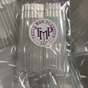 May include: A clear plastic bag filled with a large quantity of clear plastic applicators with white cotton tips. The applicators are about 4 inches long. The bag has a white label with the text "Truly Made Plastics, TMP, LLC" in black.