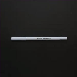 May include: White edible ink marker on a black background. The marker is labeled "Edible Ink Marker".