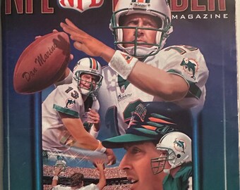 May include: NFL Insider Magazine cover featuring Miami Dolphins quarterback Dan Marino. The cover art includes images of Marino in action, the NFL logo, and the text "STADIUM EDITION". The magazine cover also includes the text "Miami Dolphins vs. Baltimore Ravens".