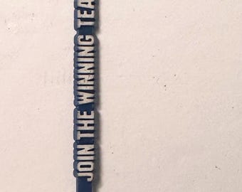 May include: A blue plastic flag-shaped item with the word "EASTERN" and a logo on the flag. The text "JOIN THE WINNING TEAM" is printed vertically on the stem. The item has a rounded top and a pointed bottom.