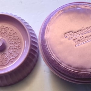 May include: Two-piece, light purple, vintage kitchenware. One piece is a round, fluted bowl with an ornate, raised floral design in the center. The other piece is a lid with the words "Persian Lilac" embossed on the top.