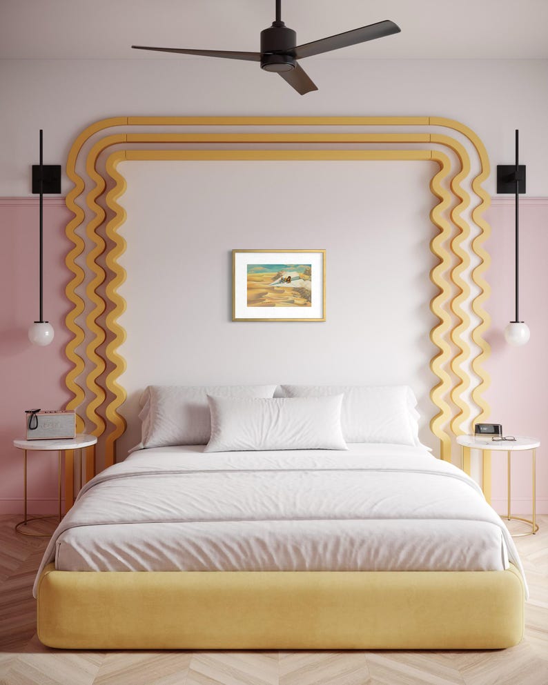 May include: A bedroom with a yellow bed frame and headboard, white bedding, and a framed artwork. The walls are pink and white, with a yellow decorative element. Black ceiling fan and sconces complete the decor.