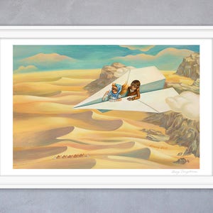 May include: A framed art print depicts two figures in aviator gear riding a paper airplane over a desert landscape. The artwork features warm tones of yellow and brown, with a blue sky and clouds. The print is signed.