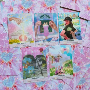 May include: A set of 5 illustrated cards with pink and blue backgrounds. Each card features a different image and text. The text on the cards includes "like honey", "date night", "cash $$$", "red rose", and "love letter".
