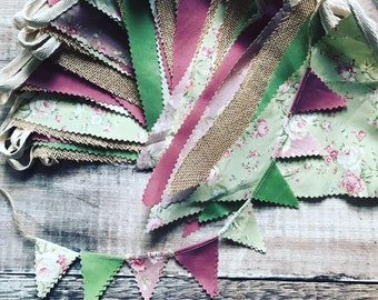 May include: A bunting banner with green, pink, and brown fabric triangles. The triangles have a floral pattern and are sewn together with white string.