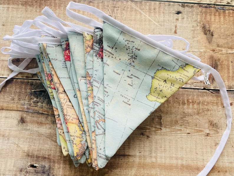 May include: A blue and yellow world map fabric bunting with white trim. The bunting is made of fabric and has a white string for hanging.