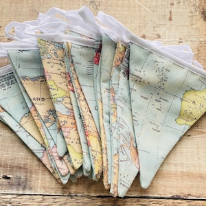 May include: A blue and yellow world map fabric bunting with white trim. The bunting is made of fabric and has a vintage look.