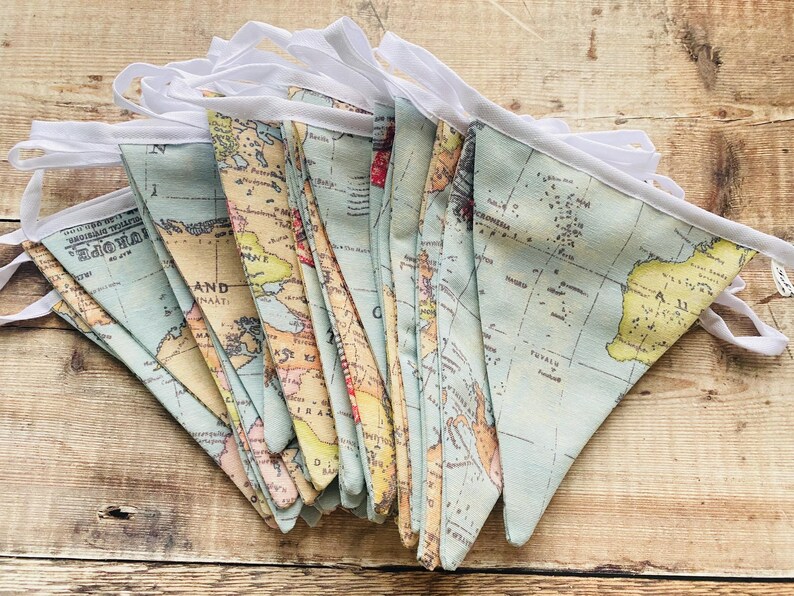 May include: A blue and yellow world map fabric bunting with white trim. The bunting is made of fabric and has a vintage look.