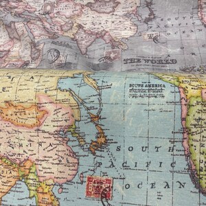 May include: A vintage world map with a blue and green color scheme. The map shows the continents of Asia, Australia, and South America. The map is printed on a textured fabric.