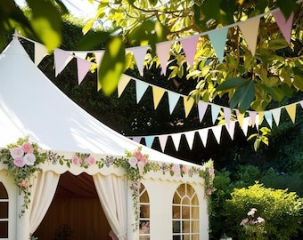 May include: A white wedding tent decorated with pink flowers and greenery. A string of colorful bunting hangs above the tent.