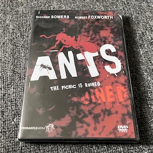 May include: DVD case for the movie "Ants" starring Suzanne Somers and Robert Foxworth. The case features a red ant with black eyes and the title "Ants" in white letters. The tagline "The Picnic Is Ruined" is also visible in white letters.