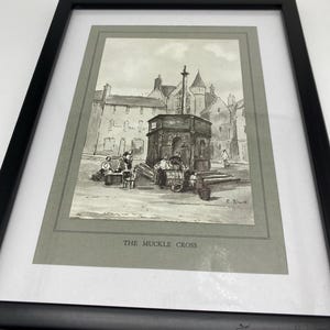 Puede incluir: Un dibujo en blanco y negro de un edificio histórico con una cruz en la parte superior. El edificio está rodeado de personas y un cartel que dice "THE MUCKLE CROSS".