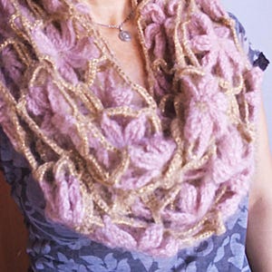 以下が含まれることがあります： 花柄のピンクとゴールドのクロシェ編みスカーフ
