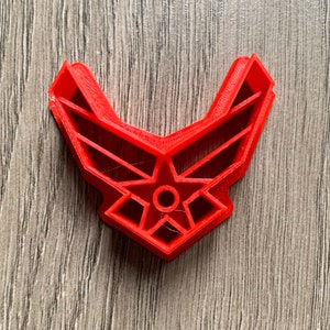 May include: Red plastic cookie cutter shaped like the United States Air Force emblem.