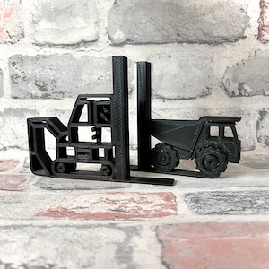 May include: Black 3D printed bookends shaped like a forklift and a dump truck. The bookends are a fun and unique way to add a touch of personality to your bookshelf.