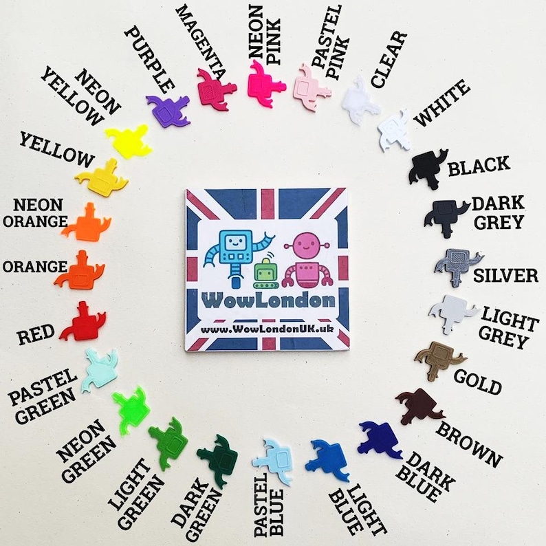 May include: A collection of colorful robot-shaped charms in various shades, including neon pink, yellow, and blue, arranged around a square card with a robot design and the text "WowLondon".