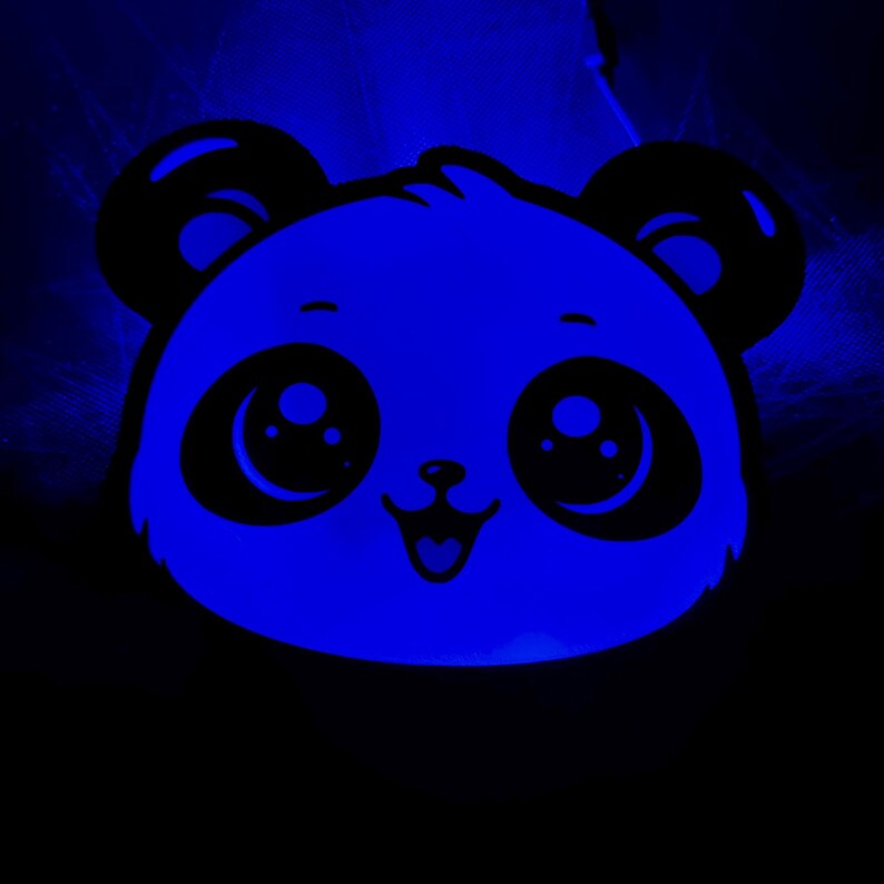 May include: A glowing blue panda face with large, expressive eyes, a small nose, and a smiling mouth. The panda's ears and facial features are black, contrasting with the bright blue glow. The background is dark, emphasizing the panda's illuminated features.