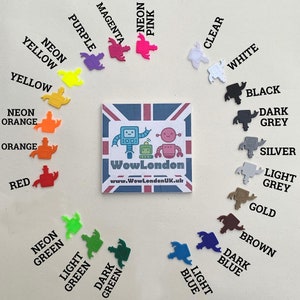 May include: A variety of colors of small robot figurines, including neon pink, magenta, purple, neon yellow, yellow, neon orange, orange, red, neon green, light green, dark green, light blue, dark blue, clear, white, black, dark grey, silver, light grey, gold, and brown. The robots are arranged in a circle around a small sign that says "WowLondon" and "www.WowLondonUK.uk".