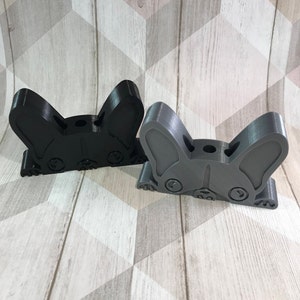 May include: Two 3D printed dog head pencil holders. One is black and the other is gray. Both have a hole in the top for pencils.