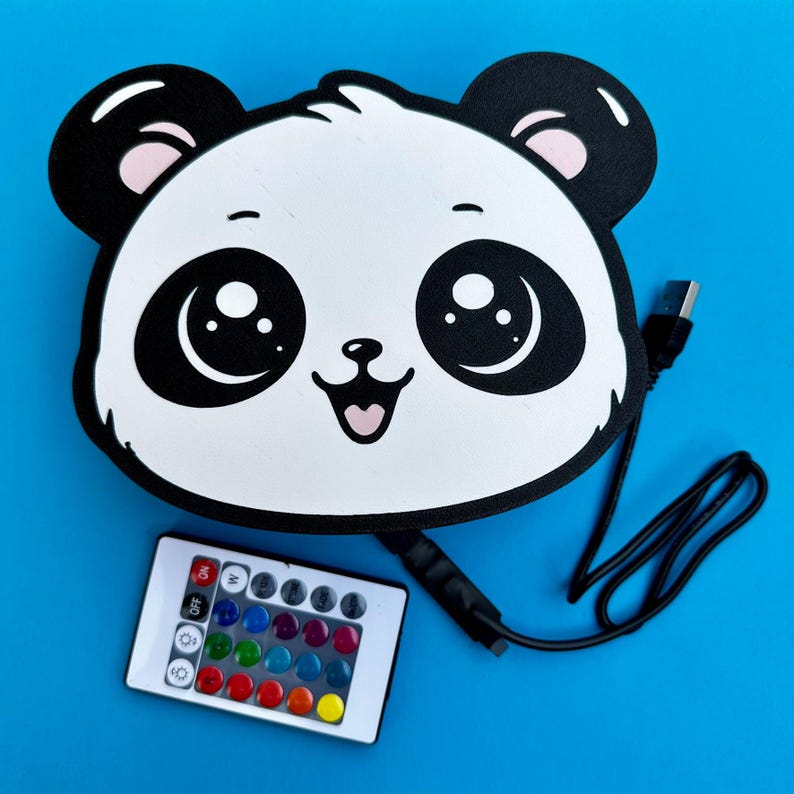 May include: A panda-shaped LED light with a remote control. The panda has a black and white design with large eyes and a smiling mouth. The remote has multiple color options. The light is connected to a USB cable.
