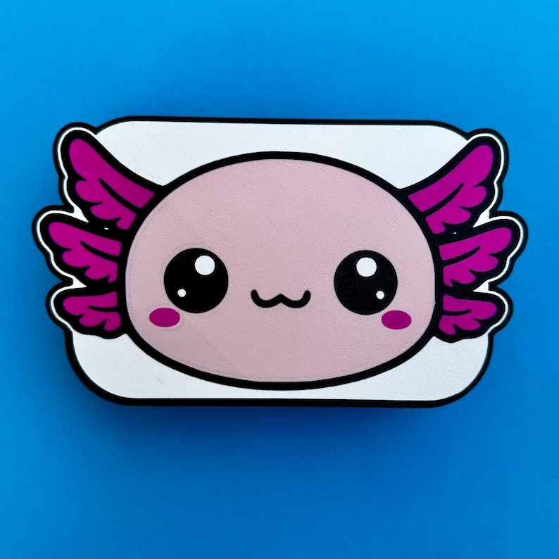 K&ouml;nnte beinhalten: Ein rosa Axolotl-Cartoon-Design mit gro&szlig;en schwarzen Augen, rosa Kiemen und einem kleinen L&auml;cheln. Das Axolotl ist vor einem wei&szlig;en Hintergrund mit schwarzer Umrandung auf blauem Grund platziert.